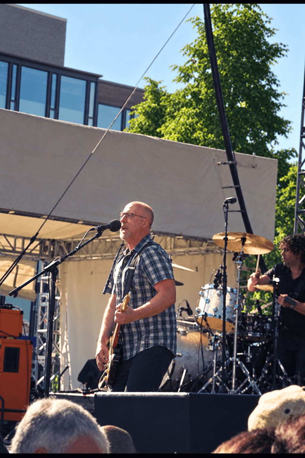 Bob Mould singing and playing guitar at an outdoor show