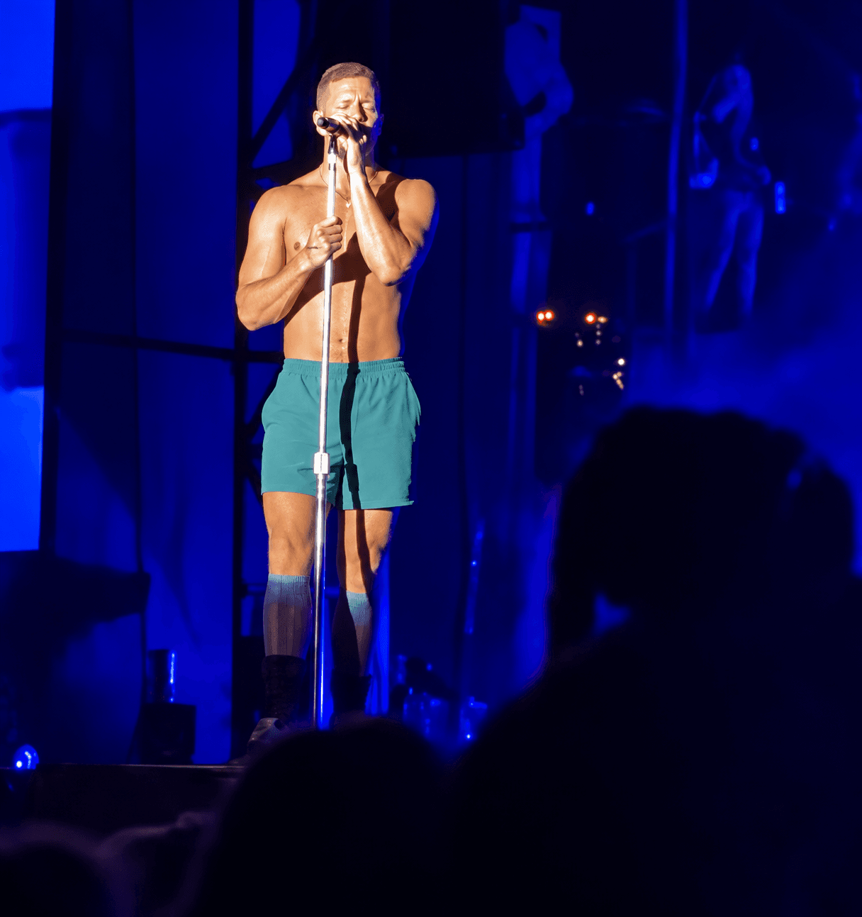 Dan Reynolds performing with Imagine Dragons under blue stage lights