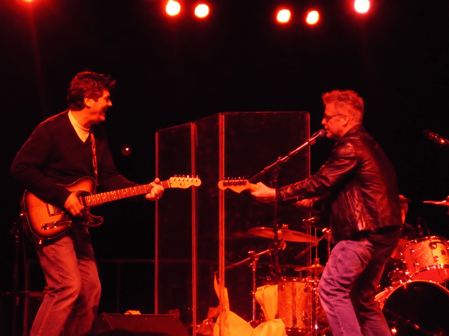 Gin Blossoms performing under red stage lights