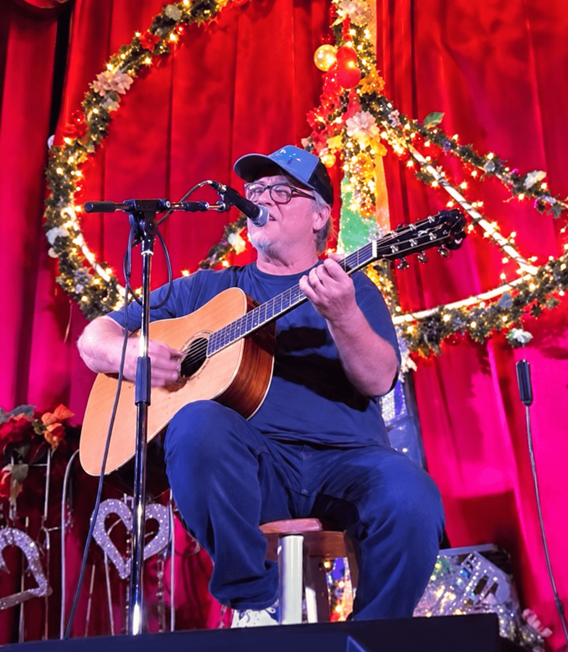 Shawn Mullins seated onstage with an acoustic guitar